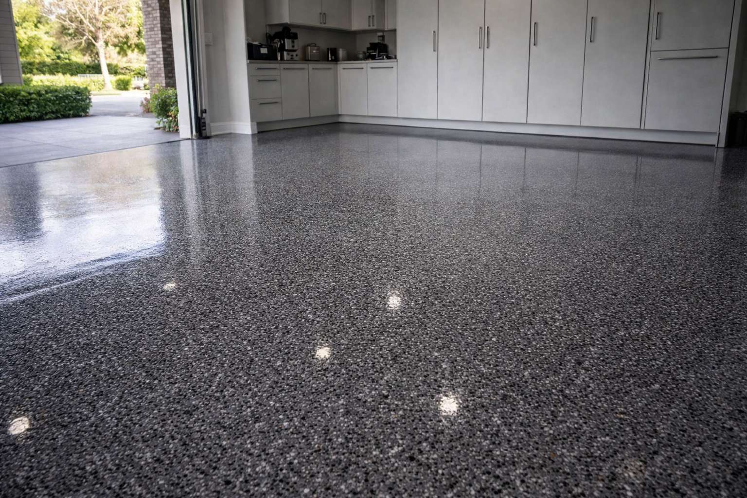 Finished ArmorClad charcoal flake epoxy flooring in an Irvine garage, showing a high-gloss, industrial-grade bond.